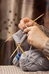 hands knitting a sock with bamboo needles