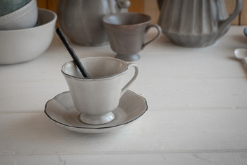 Tea set is Gray on a wooden background. Teapot, creamer, Cup and saucer on the table. Ceramic kitchenware