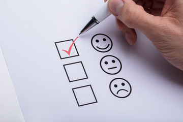 Person's Hand Ticking Off Checked Box