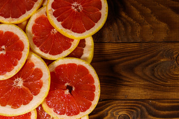 Fototapeta na wymiar Sliced grapefruits on wooden table. Top view, copy space