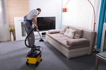 Janitor Cleaning Carpet With Vacuum Cleaner