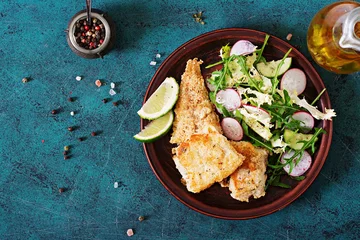 Photo sur Plexiglas Poisson Fried white fish fillet and cucumber and radish salad. Top view