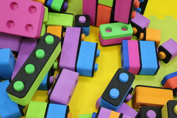 Children's constructor. Big pile plastic toy blocks.  Background of bright plastic big building blocks. Children's multicolor soft designer. Puzzle