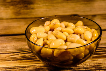White marinated haricot beans in glass bowl on a wooden table