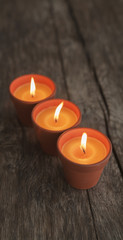 Fototapeta na wymiar trio de bougies sur fond sombre