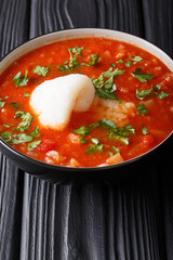Sicilian fish tomato soup with vegetables close-up in a bowl. vertical
