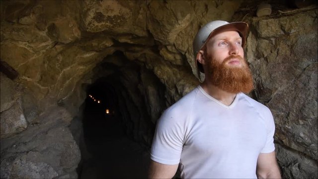 Mining worker with red beard looking into distance