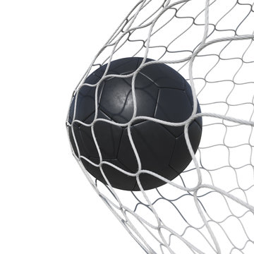 Black leather soccer ball inside the net, in a net.