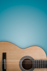 Part of an acoustic guitar on a blue background.