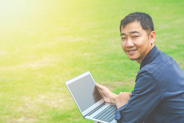 Happy asian young businessman with laptop celebrating success.