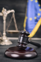 Scales of Justice, Judge Gavel and Flag of the European Union on a wooden background.