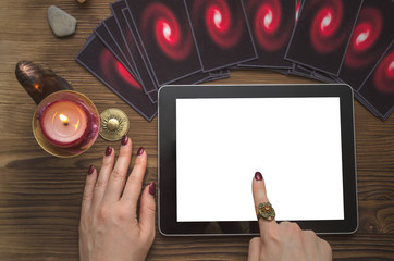 Online future reading concept. Tarot cards and tablet computer with blank screen on fortune teller desk table. Internet divination template.