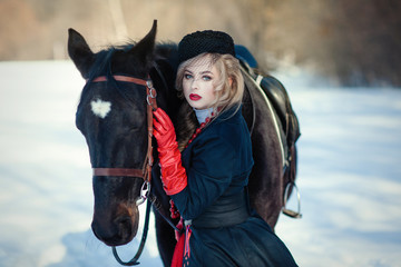 Obraz premium A girl in a long black dress with a dark horse