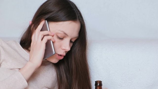 Tough Conversation To Women On The Phone. Young Beautiful Woman Drinks Beer.