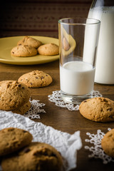 Oatmeal cookies with fresh healthy milk in the bottle on the wooden table background