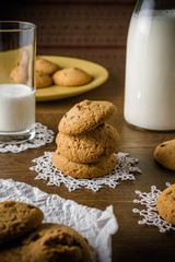 Oatmeal cookies with fresh healthy milk in the bottle on the wooden table background