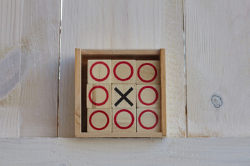 Tic-tac-toe game on white wooden background.