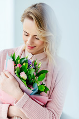 portrait of beautiful smiling woman with bouquet of flowers