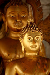 Close up of the head of a gold Thai Buddha statue, Bangkok, Thailand.