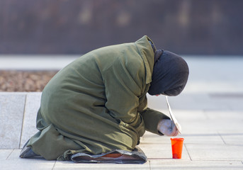 Homeless elderly woman refugee in a street