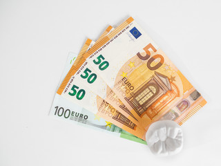 The model tooth is standing on the money in the euro currency on the white background 100