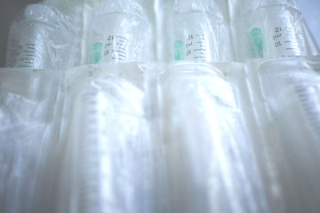 New syringes lay in rows on the surface, packed in sealed bags