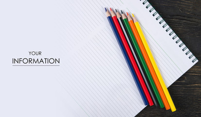 Colored pencils crayons and notebook photo above