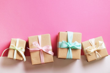 Rustic composition w/ bunch of beautiful presents in craft paper wrapping. Close up of many gifts in brown wrap with ribbon & bow.