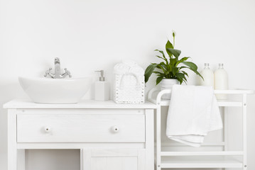 Compact bathroom interior with white vintage furniture, shelf, towels and sink