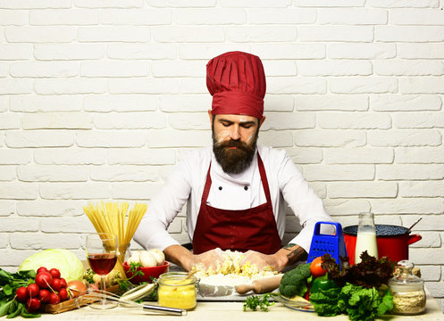 Chef makes dough. Cook with serious face in burgundy uniform