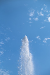 fountain closeup: water splashes against cloudy sky in sunlight with room for your copytext