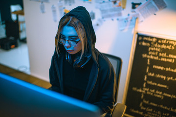 high angle view of female hacker developing malware under blue light