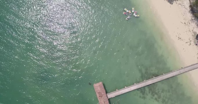 Gliding birds eye view of docks and beaches in the Malaysian tropics in summer