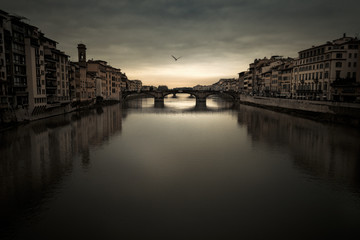 Obraz premium Florence Arno river under a moody sky at dusk 