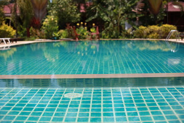 Swimming pool in tropical garden with bamboo bungalow - paradise for tourists.