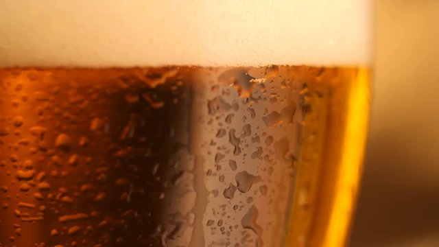 Detail of beer glass with bubbles. Close up beer background, slow motion.