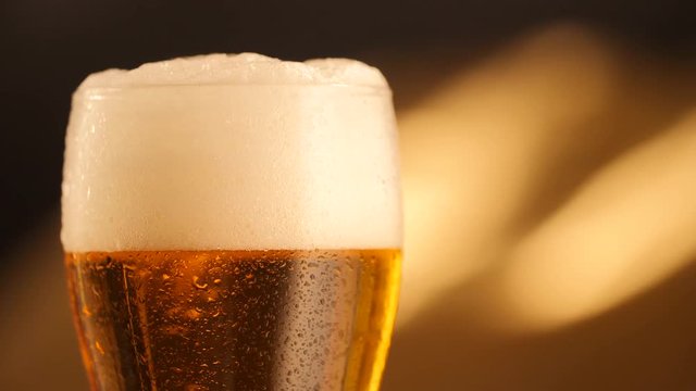 Detail of beer glass with bubbles. Close up beer background, slow motion.