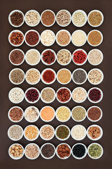 Large dried high fibre health food collection with cereals, nuts, seeds, grain, fruit, herbs and legumes with foods high in omega 3 fatty acid, antioxidants and vitamins, top view.