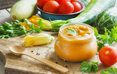 Squash zucchini paste in a glass jar surrounded by the ingredients