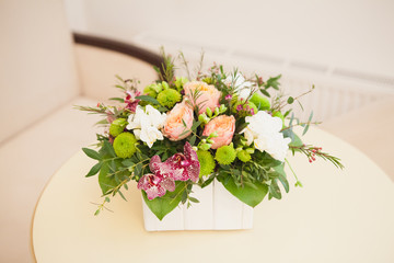 Hotel lobby with bright red floral composition on table, hospitality concept.