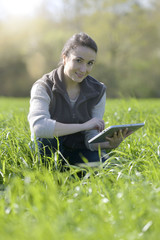 Agronomist in crop field using digital tablet