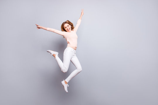 People emotion expressing feeling good mood person concept. Full-size portrait of excited cheerful joyful rejoicing delightful pretty woman jumping up showing v-sign isolated on gray background