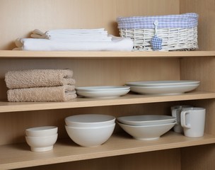 Different white dishes in cupboard in the kitchen. Scandinavian style.