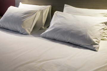 pillows on the large double bed. The concept of preparing a bed in a hotel room or at home. Modern interior