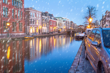 Fototapeta na wymiar Cityscape - winter view of the city canal with bridge and boats, the city of Leiden, Netherlands