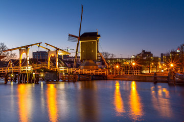 Fototapeta na wymiar Cityscape - evening view of the city canal with drawbridge and windmill, the city of Leiden, Netherlands.