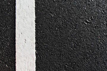 Fototapeta premium dirty white line on surface of old asphalt in countryside