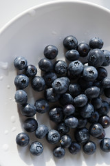 Fresh blueberries on white plate.