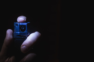 a man's hand holds a gas pepper spray in the dark, a black background. concept of safety and...