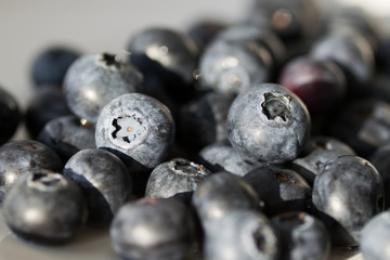Fresh blueberries in close up on white plate.
